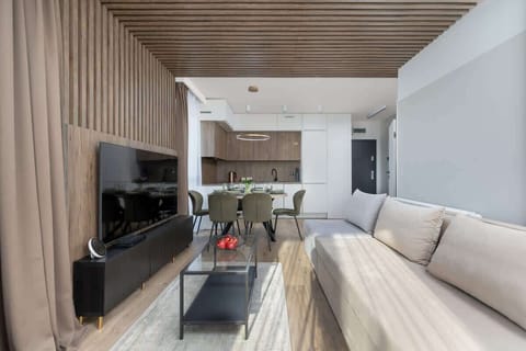 An elegant living room with bright walls, wooden accents, and a comfortable corner sofa is a perfect place to unwind.