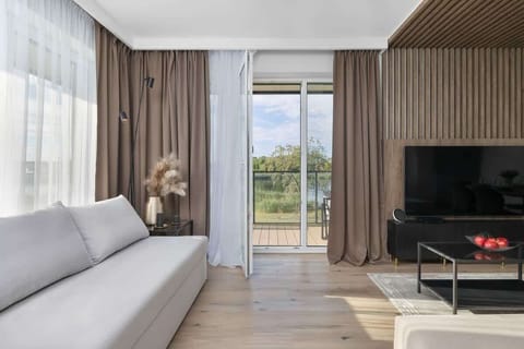 A modern living room with large windows, bright walls, and elegant furniture creates a space full of light and style.