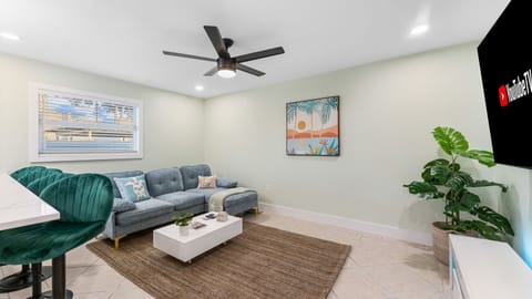 Cocoa Beach Living Room | Bright Coastal Retreat with Teal Seating, Palm Accents & Breezy Sunlit Comfort