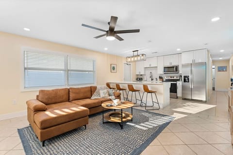 Cocoa Beach Living Space | Breezy coastal retreat with a sectional sofa, sleek waterfall island, and leather bar seating.