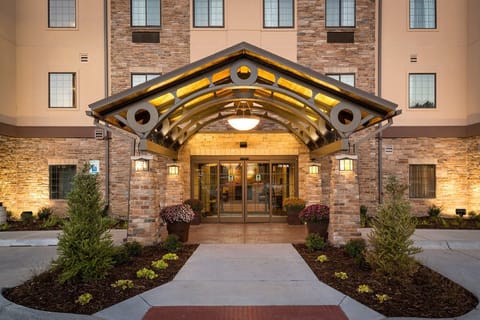 Step into a warm and inviting entrance, framed by beautiful landscaping.