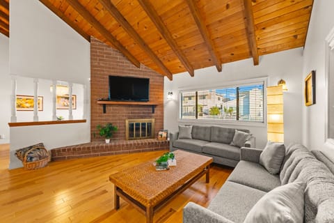 Inviting living room with cozy seating, a TV, and a charming decorative fireplace