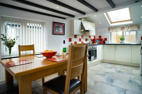 Kitchen/dining area with wood table and chairs and kitchen area