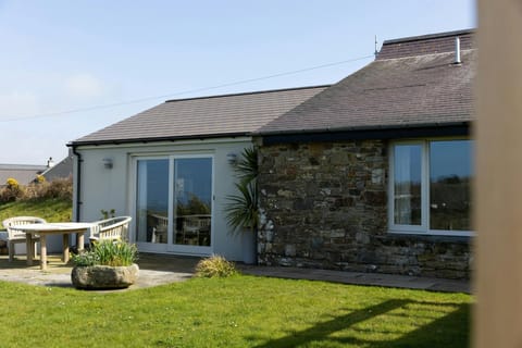Patio area with table and chairs. Planters and lawn