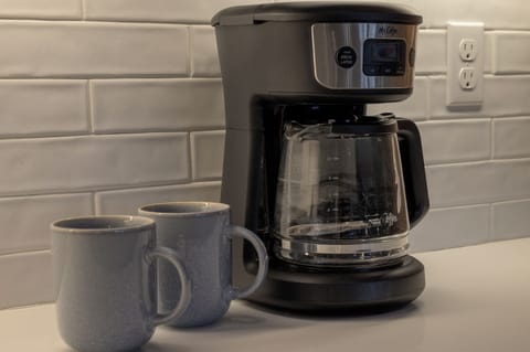 - Morning routines are easy with this sleek drip coffee maker and matching mugs - Subway tile backsplash and clean white counters add charm to the setup - Brew your favorite blend and savor it at the island or out on the mountain view deck