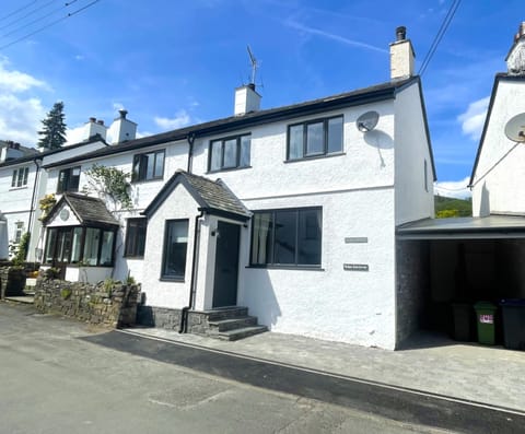 The front view of Glen Cottage, the property has a covered private parking space with shared EV charger