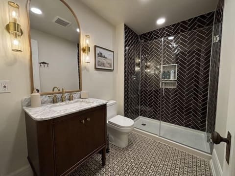 Beautifully updated bathroom featuring a marble vanity, modern fixtures