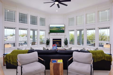 Fireplace, Smart TV, and large windows fill the room with light.