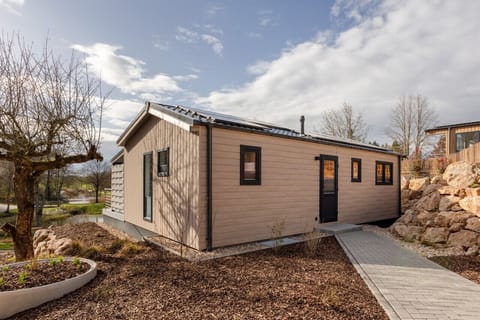 Charming standalone chalet w/ a private entrance, set against a dramatic open sky.
