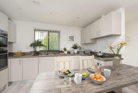 The Wood Shed, Perranporth. The kitchen boasts an electric oven and hob, microwave, fridge/freezer, and dishwasher.