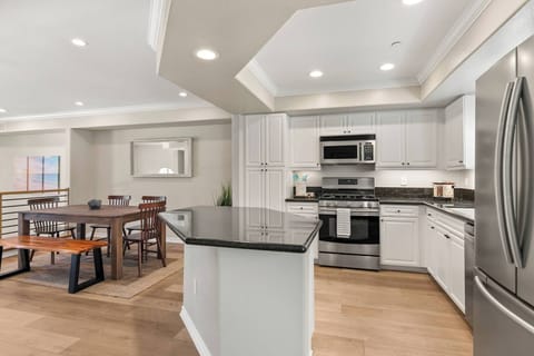 White, wooden open kitchen w/stainless steel appliance
