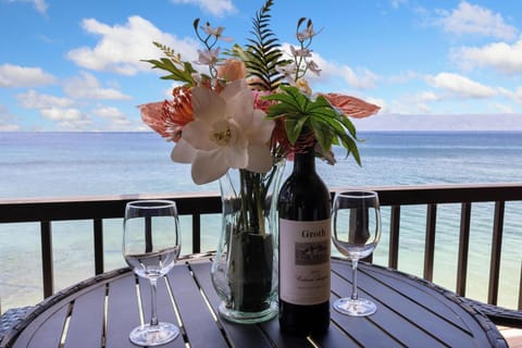 Enjoy a bottle of wine with stunning ocean views on this beautifully set balcony dining table, perfect for a relaxing getaway."