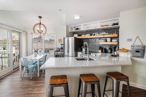 A well provision updated kitchen, with countertop seating and a dining table 