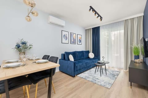 A spacious living area with a large balcony window invites natural light and offers a pleasant spot to relax on a stylish sofa.