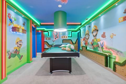 Enter a lively game room adorned with playful murals and neon accents that create a fun atmosphere. Enjoy friendly competitions at the sleek pool table and soak in the joyful vibe brought by the vibrant decor throughout the space.