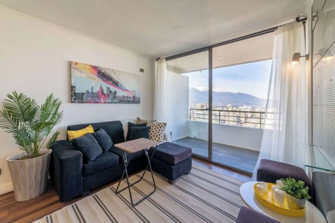 Relax in a cozy living room with breathtaking city and mountain views, perfect for unwinding after a day of exploring Santiago.
