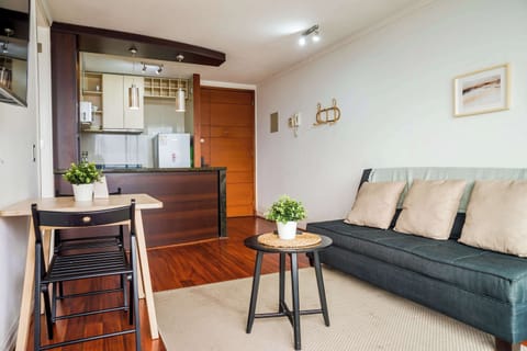 Private living room with a charcoal sectional, cozy beige cushions, and an open kitchenette with a polished wood breakfast island.