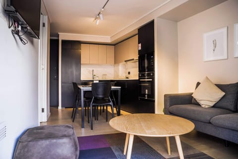 Relax in this modern studio with a stylish kitchen, cozy seating, and all the amenities for a perfect stay.
