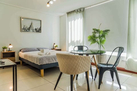 Bright and cozy studio with a comfy bed and dining area, perfect for a relaxing stay in the heart of the city.
