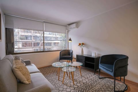 Cozy living area with stylish seating and natural light, perfect for relaxation in the heart of the city.