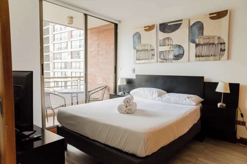 Cozy bedroom with balcony access, perfect for enjoying city views and relaxation.