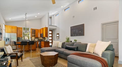 Spacious living room with high ceilings, extra large sofa, full kitchen, and smart tv!