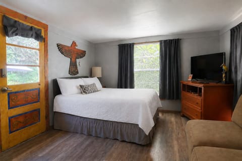 Relax and watch TV in the beach studio's bed after a long day.