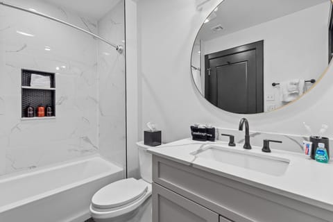 The studio bathroom includes fresh towels, a hairdryer, and complimentary toiletries. Conveniently located near the living area, it's stylish and practical—perfect for guests, families, or sharing during group stays at 888 Baronne.