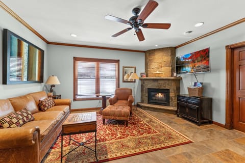 Living Room: Gas fireplace, TV, couch, armchair w/ottoman, ceiling fan, open layout