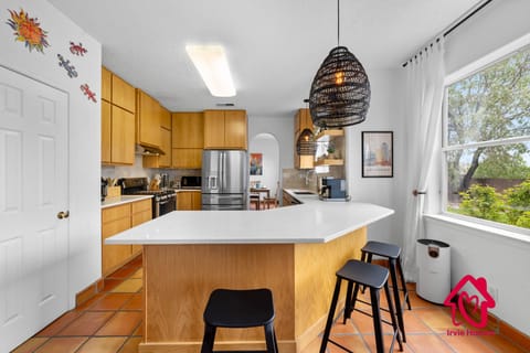 "Modern kitchen with light wood cabinetry and stainless appliances."