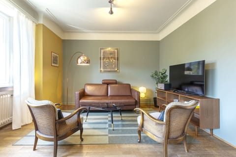 Relax in the spacious and elegantly furnished living room, featuring a comfortable sofa, flat-screen TV, and ample natural light. Perfect for unwinding after exploring Luxembourg.