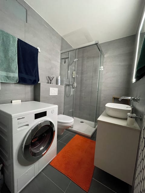 Modern bathroom with a shower and a washing machine 
