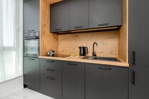 A kitchenette with black cabinets and a wooden worktop. The whole creates the perfect space for preparing home-cooked meals. 
