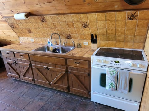 KITCHEN:  Features an electric range, sink, counter space, cabinets, refrigerator, microwave, and coffee maker.  (No dishwasher though.)