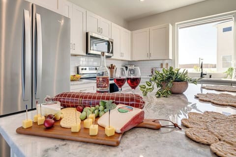 Open kitchen with stainless steel appliances, large island, breakfast bar seating, and is fully equipped with your basic cooking essentials.