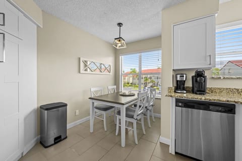 Sunny breakfast corner with seating for four and views of the palm-lined community