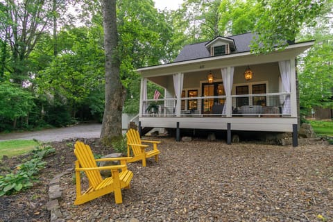 Bold yellow chairs greet you on the tree-speckled front yard, with a cozy porch in the background.