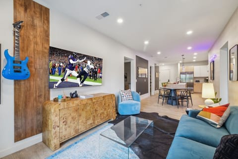 Warm and stylish living room featuring a large Smart TV, elegant furnishings, and a spacious balcony.