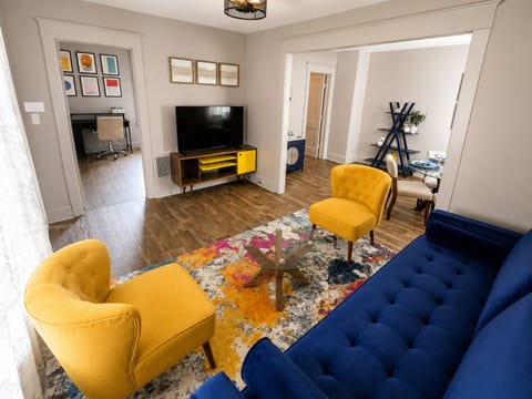 Open concept living room with Smart TV, dedicated workspace, and dining area