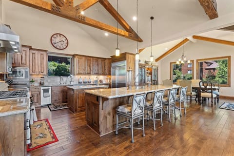 This kitchen has a large island for prep and entertaining, rustic beams, and modern finishes.