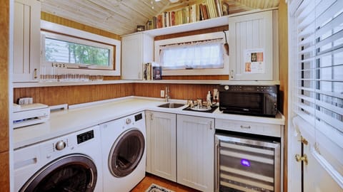 The pantry extends from the kitchen and is complete with a washer, dryer, microwave, and wine chiller...