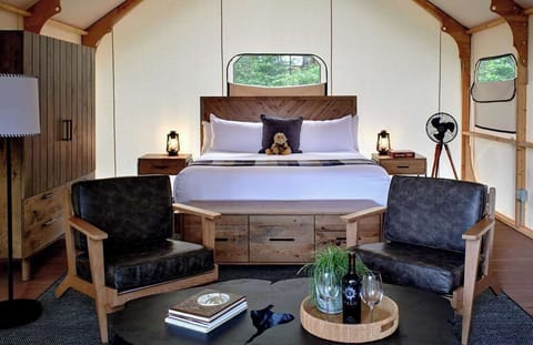 Cozy and stylish glamping interior featuring a plush bed and sitting area for ultimate relaxation.