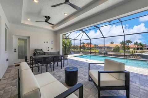The best of Florida outdoor living. Lanai with outdoor kitchen overlooking the sparkling private pool and canal