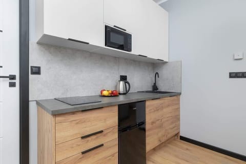 A wider view of the kitchen showing modern cabinetry and all essentials. A compact space for convenient cooking.