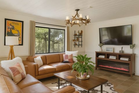 Kick back and relax in this cozy living room—comfy couches, big smart TV, and peaceful forest views.