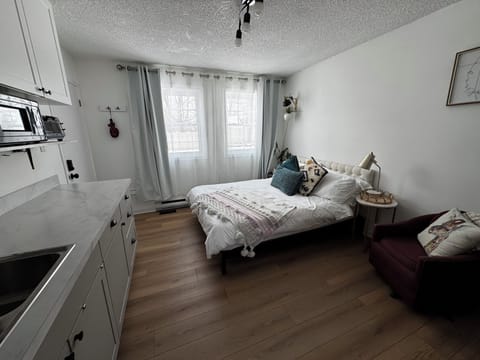 Queen bed, dining area, kitchenette with fridge, cooktop, microwave, toaster.