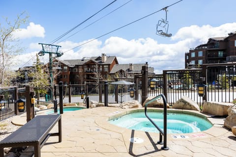 Unwind in bubbling hot tubs beneath the ski lift, surrounded by mountain architecture and bluebird skies.