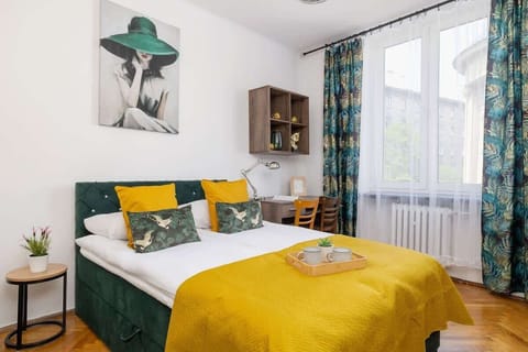 A bright room with a large window, soft bedding and colorful cushions invites you to relax after a day full of experiences.