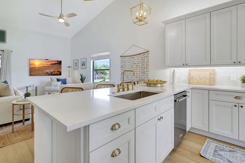 Brass pulls and fixtures accent the shiny white quartz counters