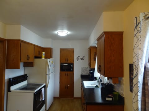 Kitchen with stove, full refrigerator, and most essentials